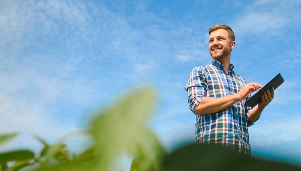 Person with a tablet smiling on a field